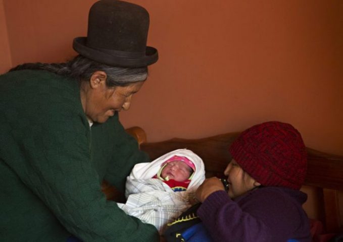 Una partera entrega un recién nacido a su madre en Patacamaya.
