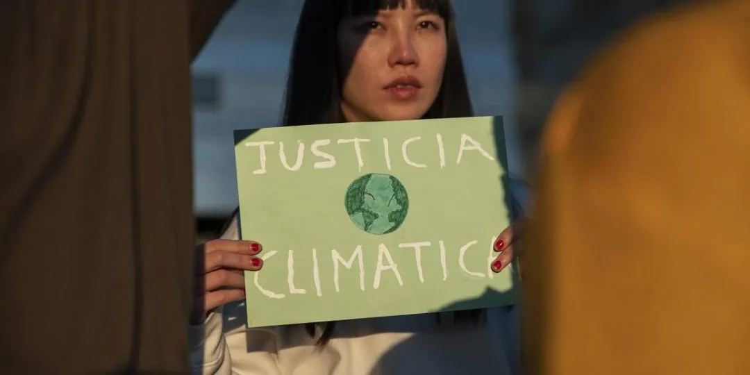 Activistas jóvenes sosteniendo un cartel sobre justicia climática.