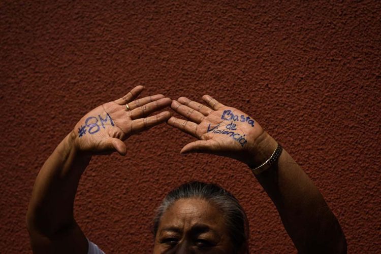 Angélica, miembro de la Plataforma de Lucha contra la Violencia hacia las Mujeres de Santa Cruz, escribe un mensaje en sus manos en contra de la violencia machista durante las preparaciones para la marcha de protesta por el 8M en Bolivia