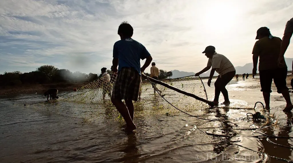 Pescadores en el río Pilcomayo despliegan una de sus redes durante un atardecer.