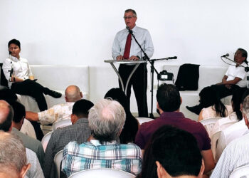 Hombres adultos y ancianos, calvos y con canas, mirando el escenario de un encuentro libertario en Bolivia