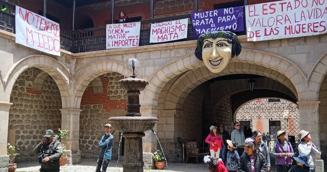 Patio central de la Casa de la Moneda en Potosí con afiches feministas colgados de las balaustras.