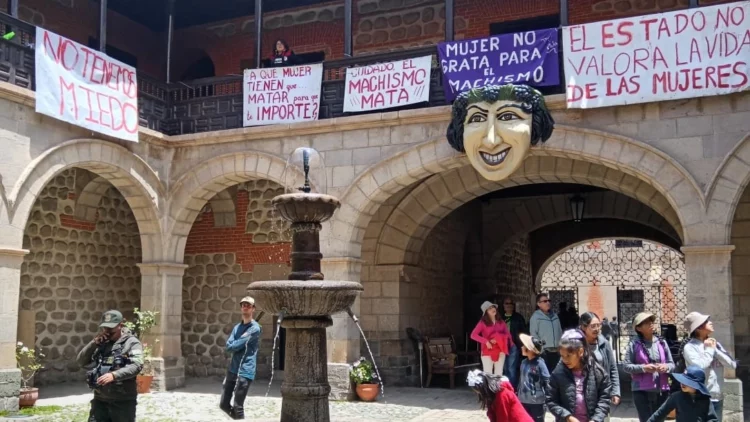 Patio central de la Casa de la Moneda en Potosí con afiches feministas colgados de las balaustras.