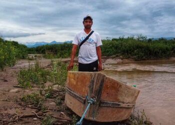 Un indígena Weenhayek en la vera del Pilcomayo junto a un bote artesanal.