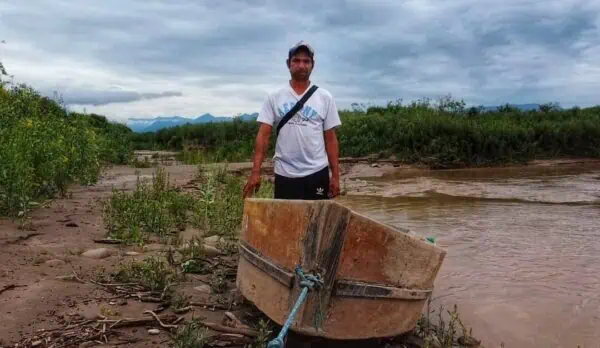 Un indígena Weenhayek en la vera del Pilcomayo junto a un bote artesanal.