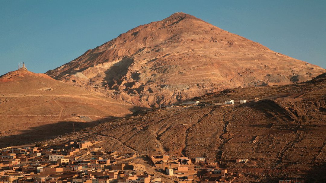 Paisaje del Cerro rico de Potosí durante un atardecer. En las faldas de una de las montañas se ven muchas casas a medio construir.