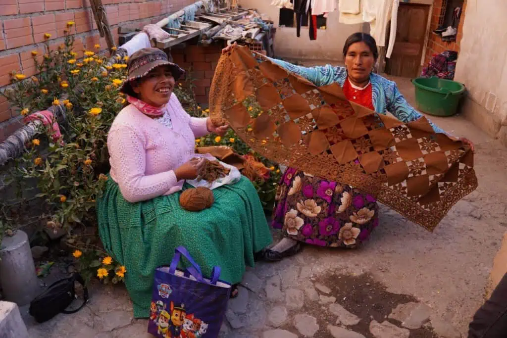 Mujeres del grupo Cholitas escaladoras tejiendo lana de alpaca. 