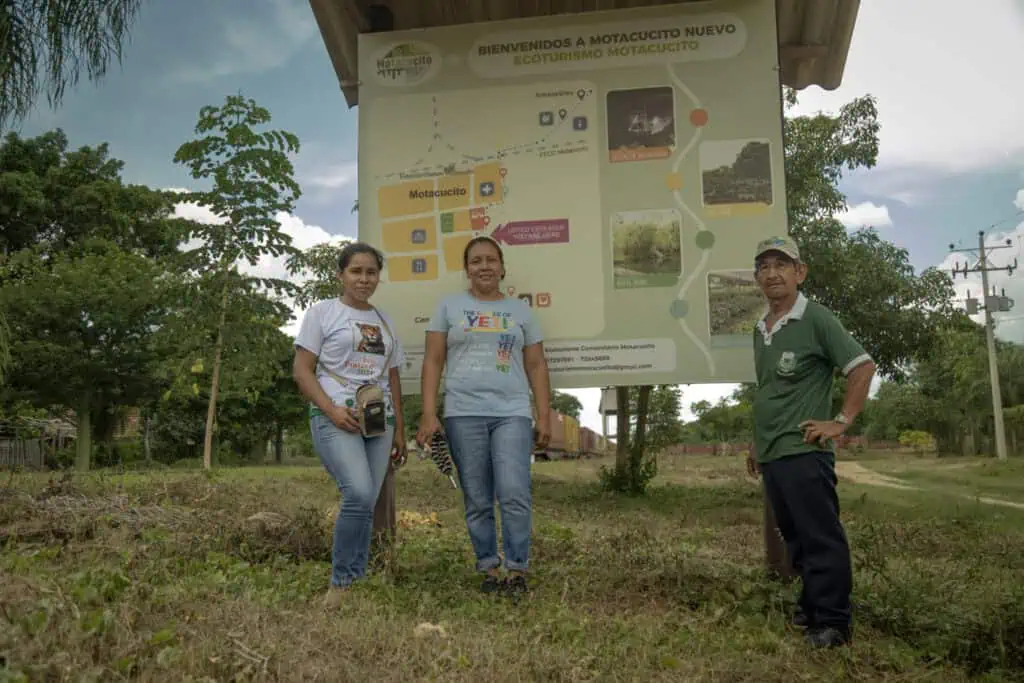 Quidian Román, Ana María Tomichá y Roberto Viera delante del panel que muestra los destinos de ecoturismo en Motacusito