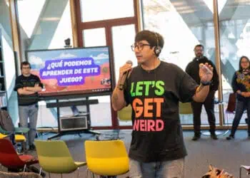 Mijail Miranda de pie con varias personas alrededor, hablando sobre la experiencia de gamificar estrategias contra la desinformación