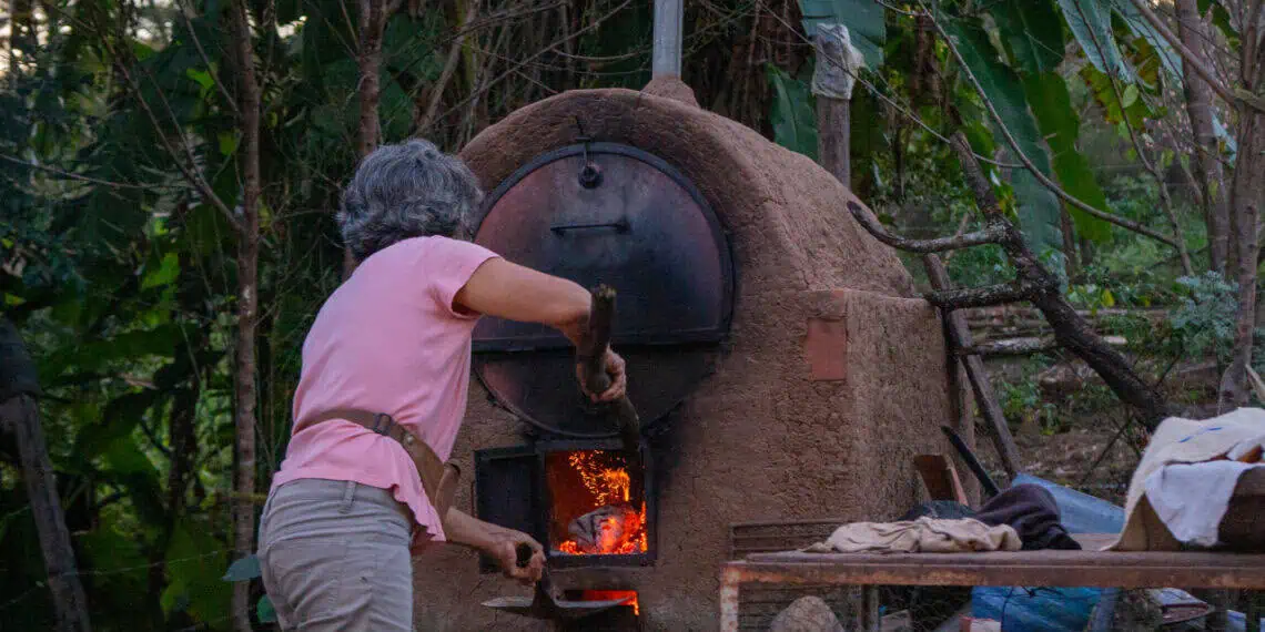 La defensora ambiental Nelly Coca, preparando el horno de barro para hacer pan. Foto: Leticia Aquino Chura